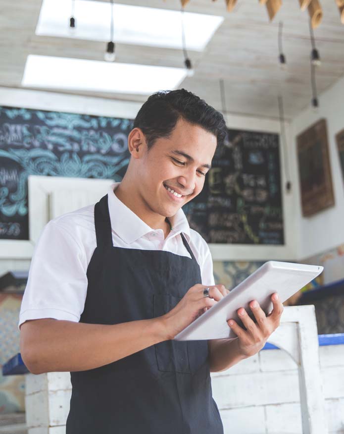 Young male cafe owner with tablet